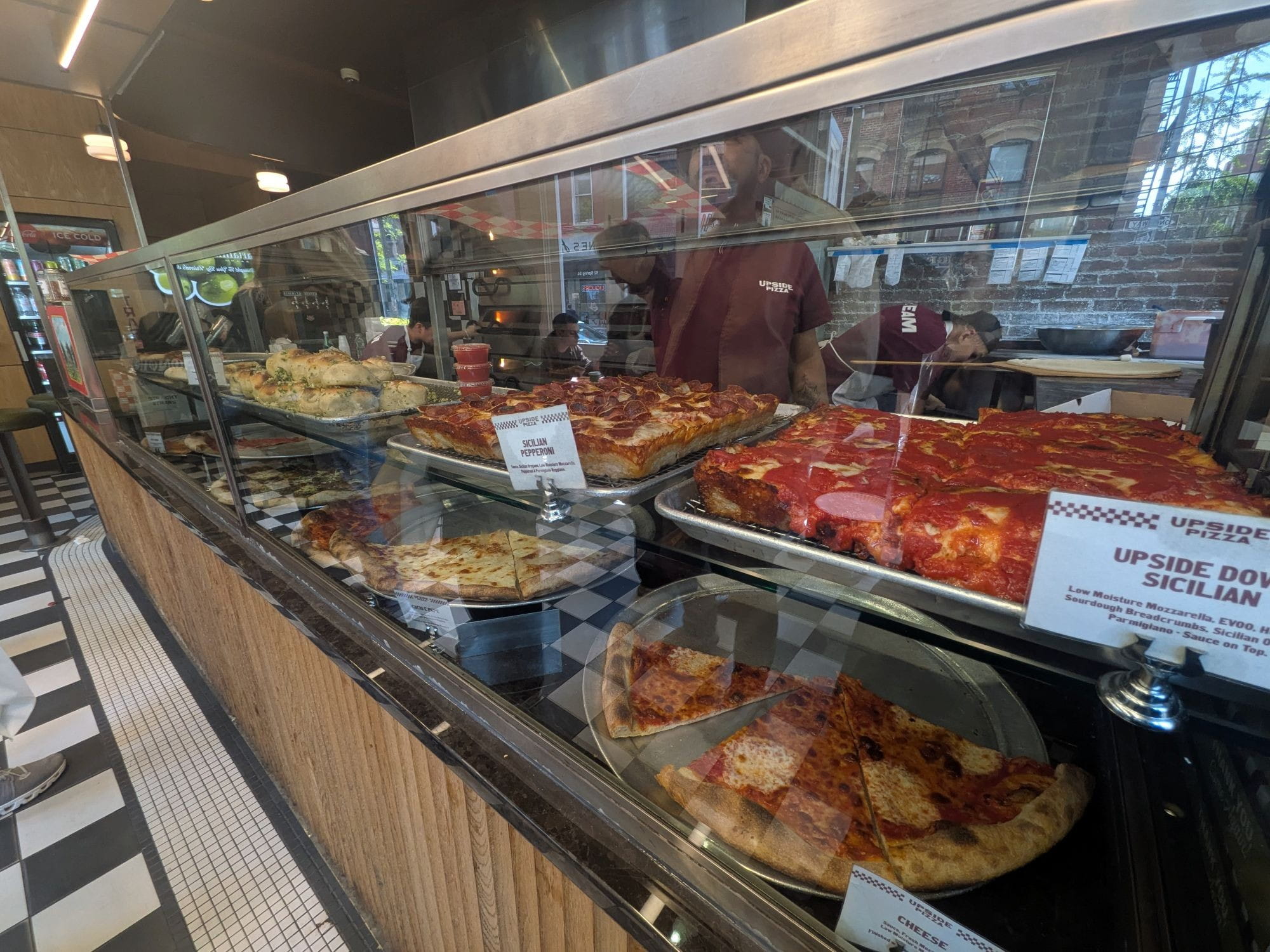 Pizza counter at Upside Pizza showing Sicilian slices